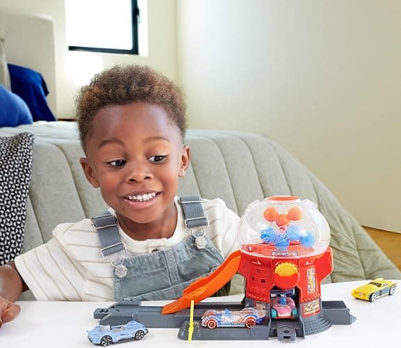 Hot Wheels Toy Car Track Set, Gumball Machine Playset with 1:64 Scale Die-Cast Donut-Shaped Vehicle & Speed Snap Track, Downtown City Candy Shop thumbnail 2