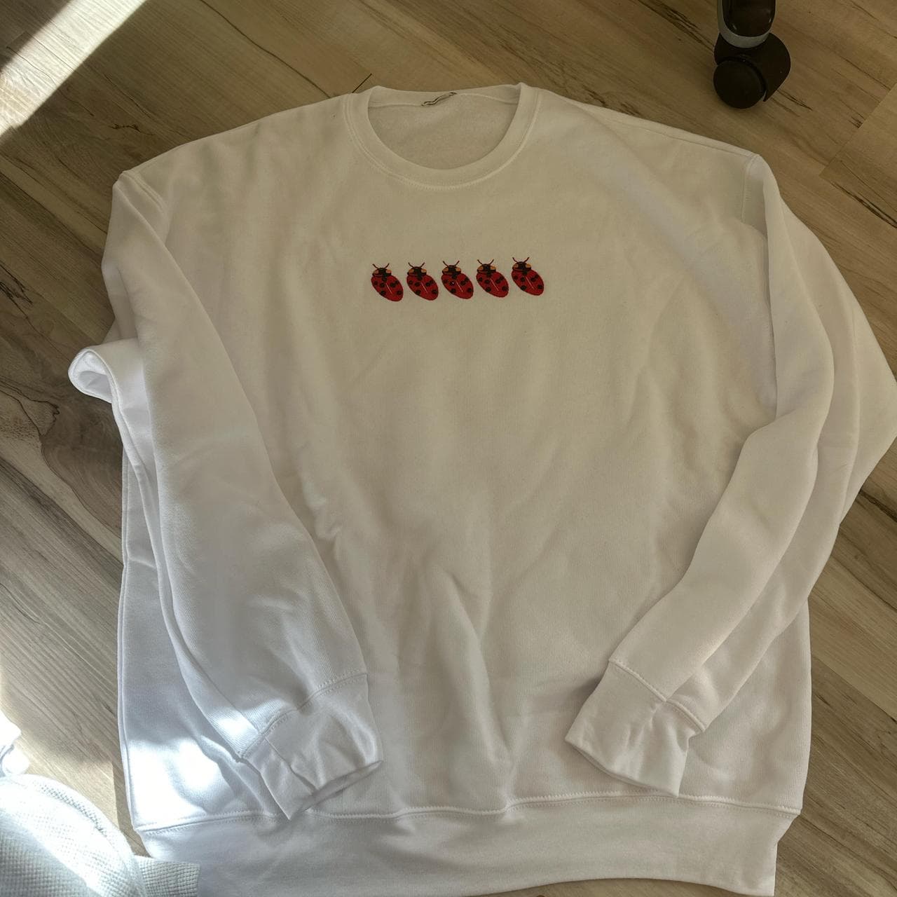 White crew neck sweatshirt with red ladybug design... thumbnail 3