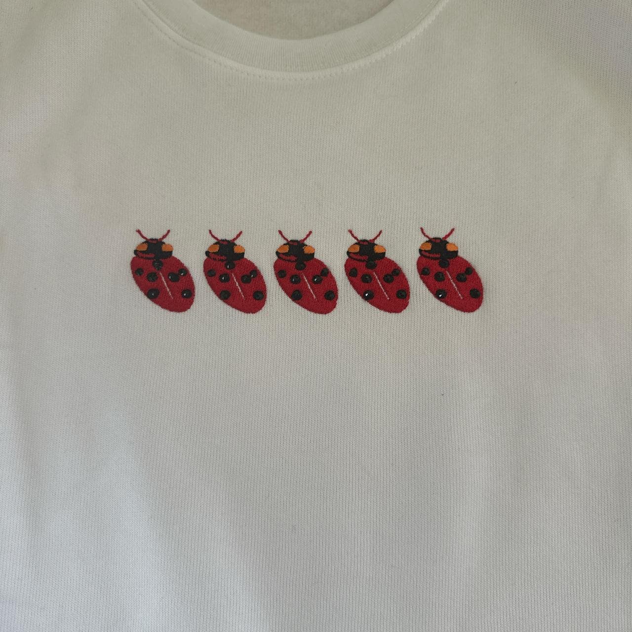 White crew neck sweatshirt with red ladybug design... thumbnail 4