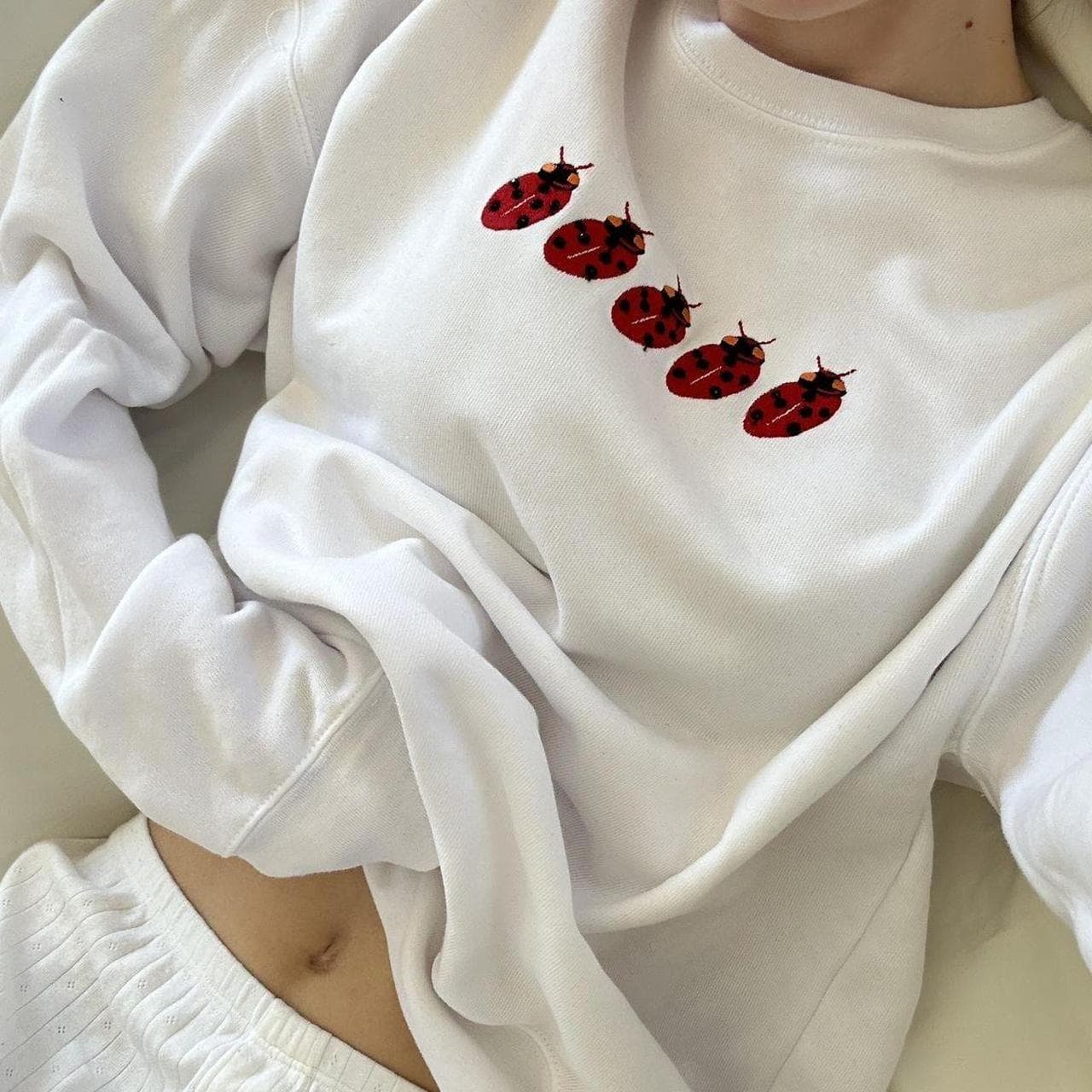 White crew neck sweatshirt with red ladybug design... - Image 1